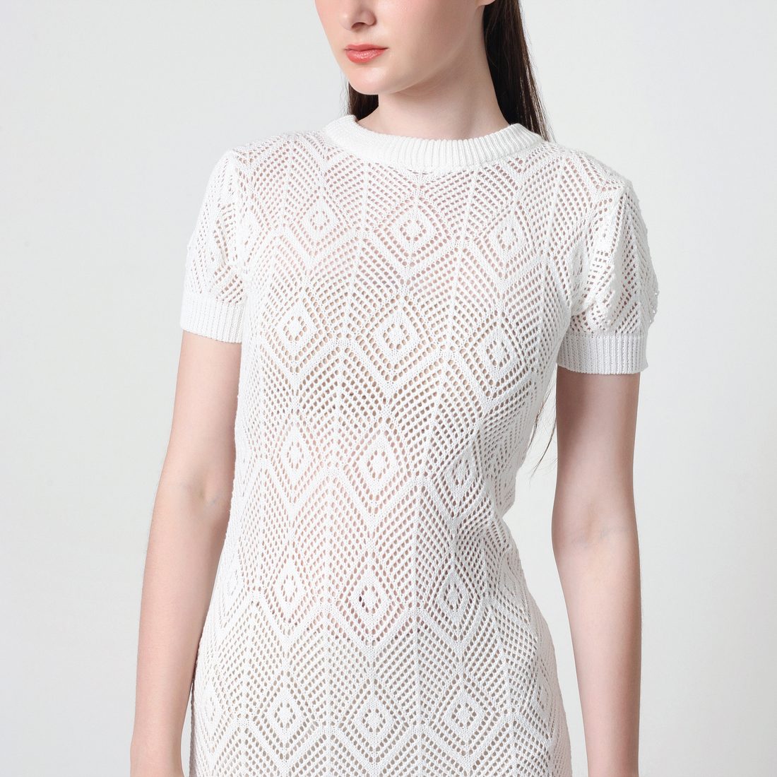 Model wearing an openwork knit dress made by Lualua